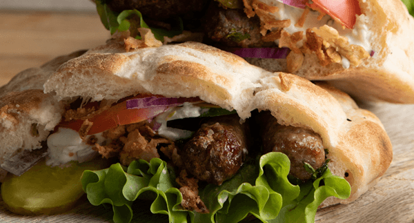 Kryddiga cevapcicis i somunbröd med krispig sallad, tzatziki & pickles