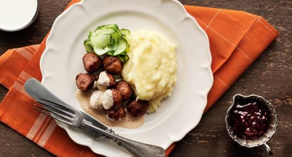 Köttbullar med potatismos, inlagd gurka, rårörda lingon och gräddsås